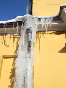 Gutter in the ice against a yellow wall